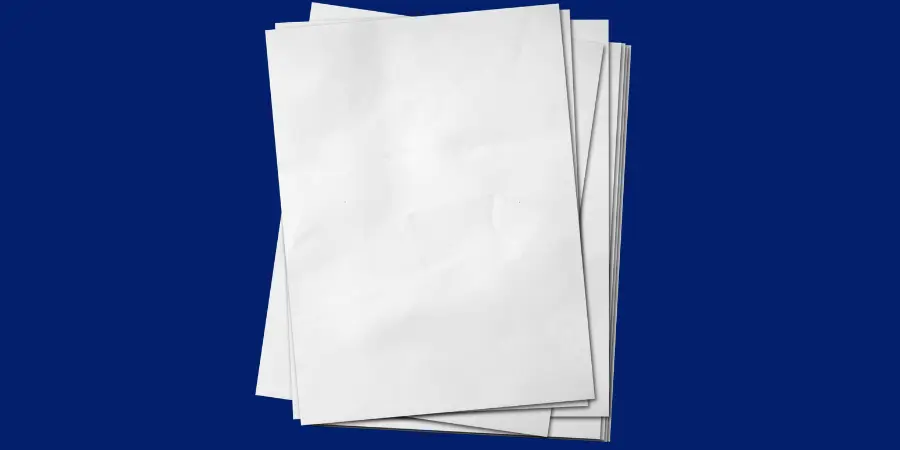 Stack of blank white paper sheets slightly spread placed on a solid blue background