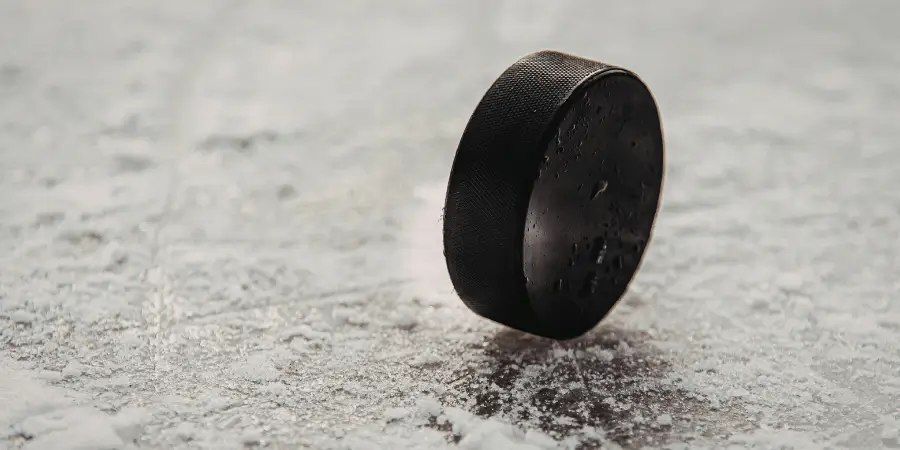 Stacked hockey pucks giving an eleven inch height comparison for sports fans