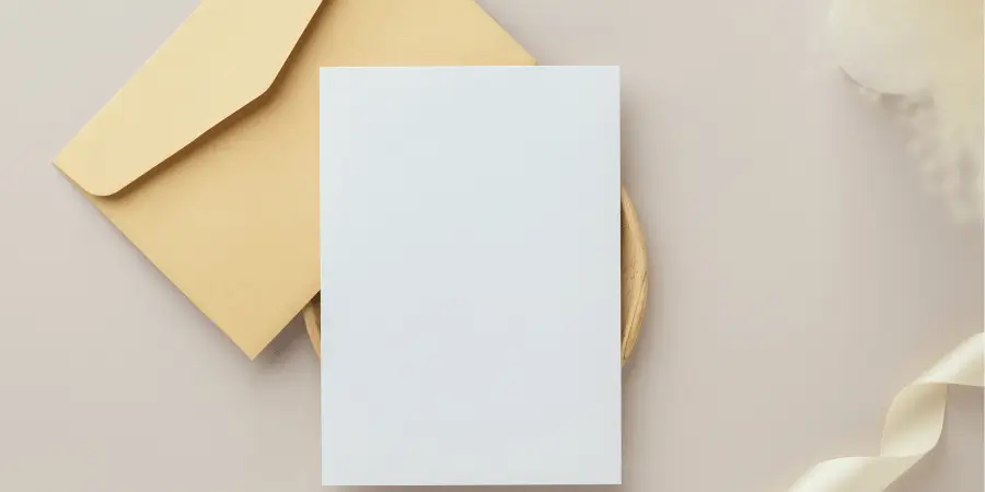 A7 envelope and blank greeting card placed on table for stationery size comparison reference