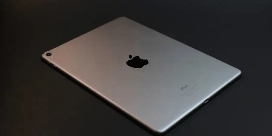 Apple iPad tablet placed on dark surface showing sleek design and compact tablet dimensions