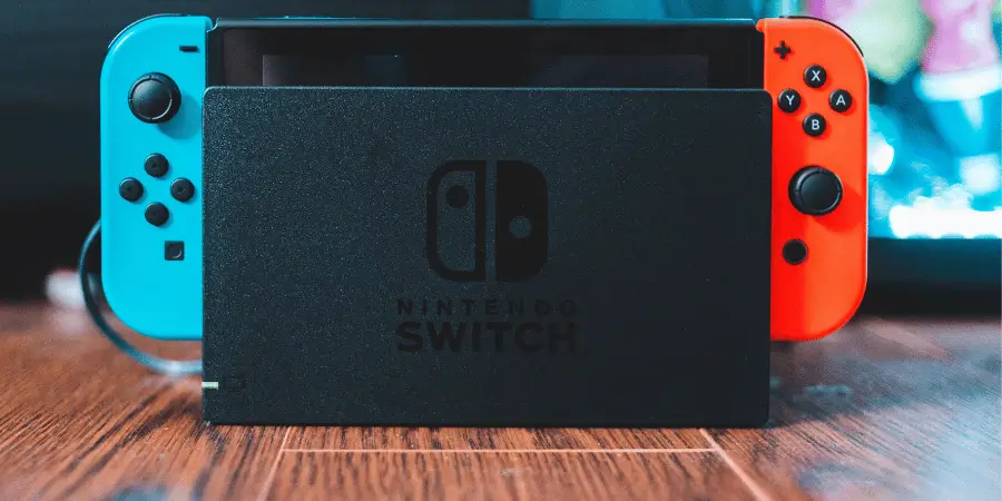 Nintendo Switch dock on wooden table showing one of the common things that are 7 inches long