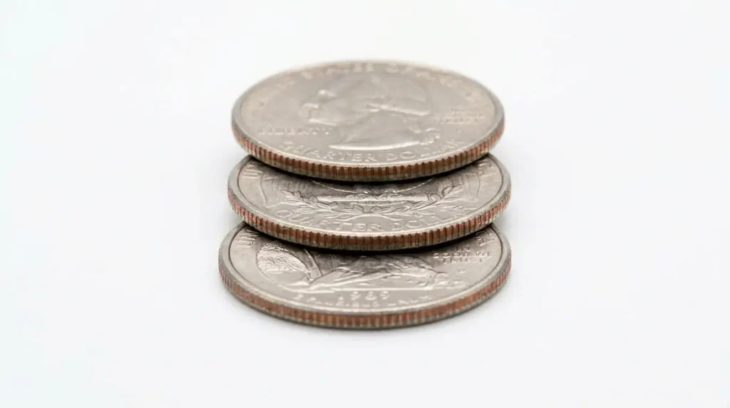 Three US quarter coins placed side by side on a plain white surface