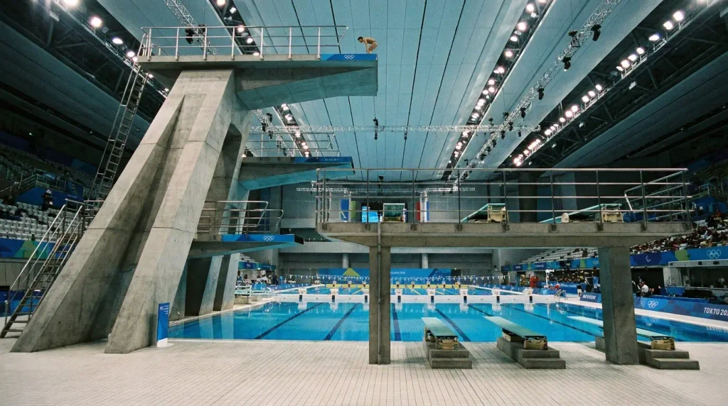 Olympic diving platform rising above an indoor competition swimming pool